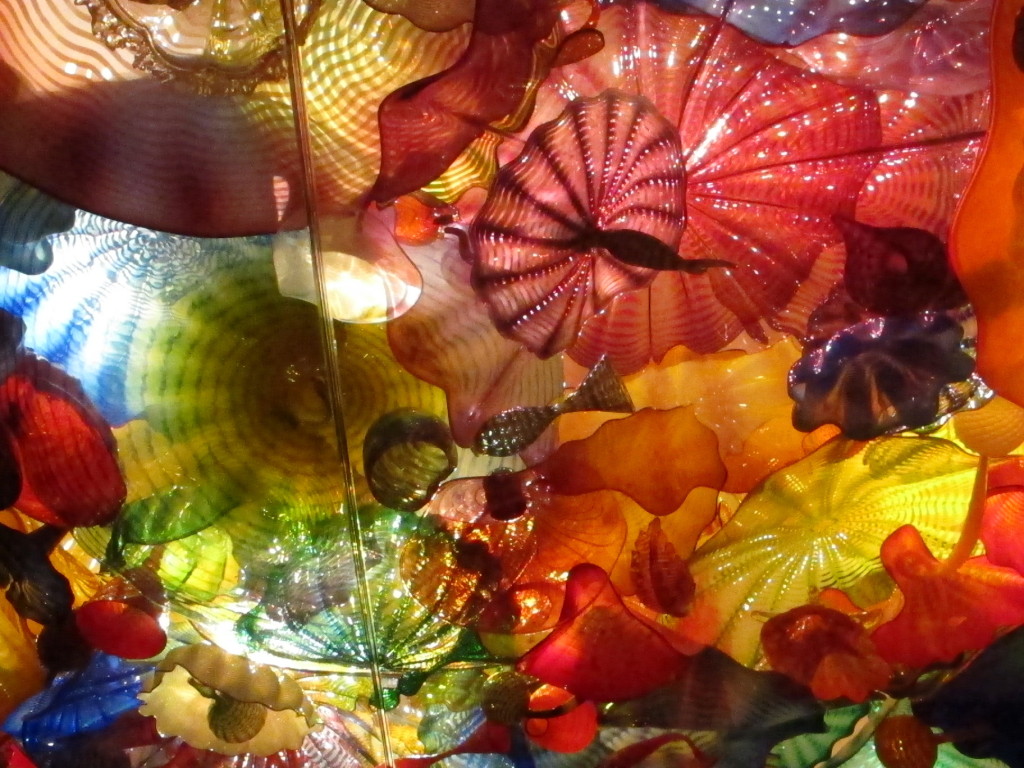 An exhibit where you look up at a collection of glass work in the ceiling.